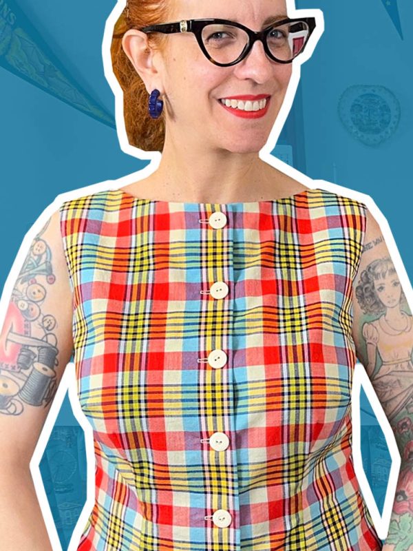Tasha wearing a red and turquoise plaid sleeveless top, matched across the front