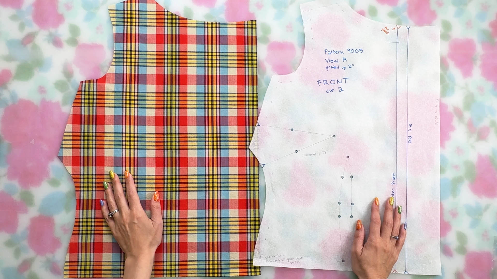 one piece of cut out plaid fabric next to the sewing pattern piece